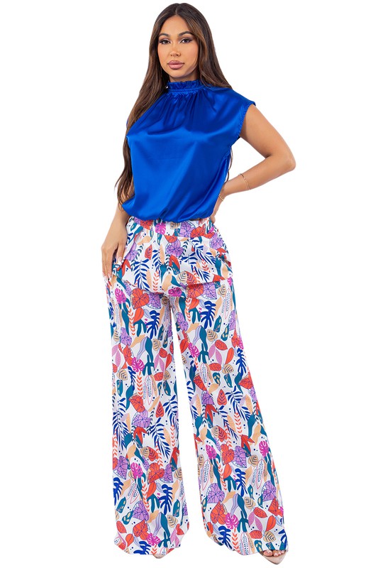 Elevate your style with the Royal Bloom Palazzo Pant Set. This stunning two-piece ensemble features a pair of flower-designed palazzo pants and a satin-like royal blue top, creating a perfect blend of elegance and comfort. The palazzo pants boast a vibrant floral pattern that adds a touch of whimsy and sophistication to your look, while the wide-leg design ensures a flattering and comfortable fit.